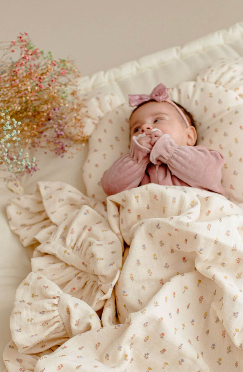 Baby girl in light spring muslin baby blanket