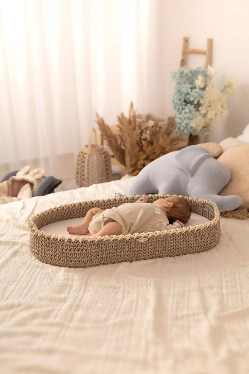 Baby lying on a handmade crochet changing basket