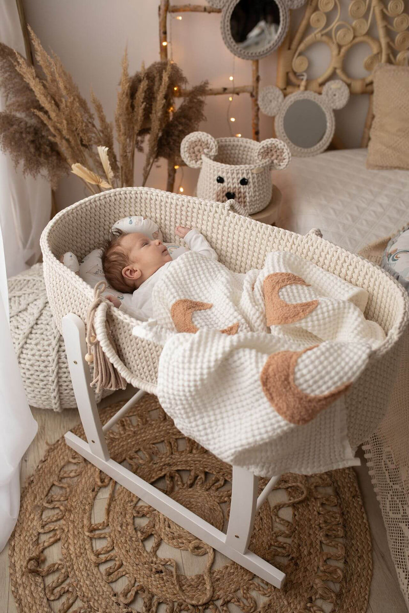 Baby sleeping in a handmade crochet Moses basket cream