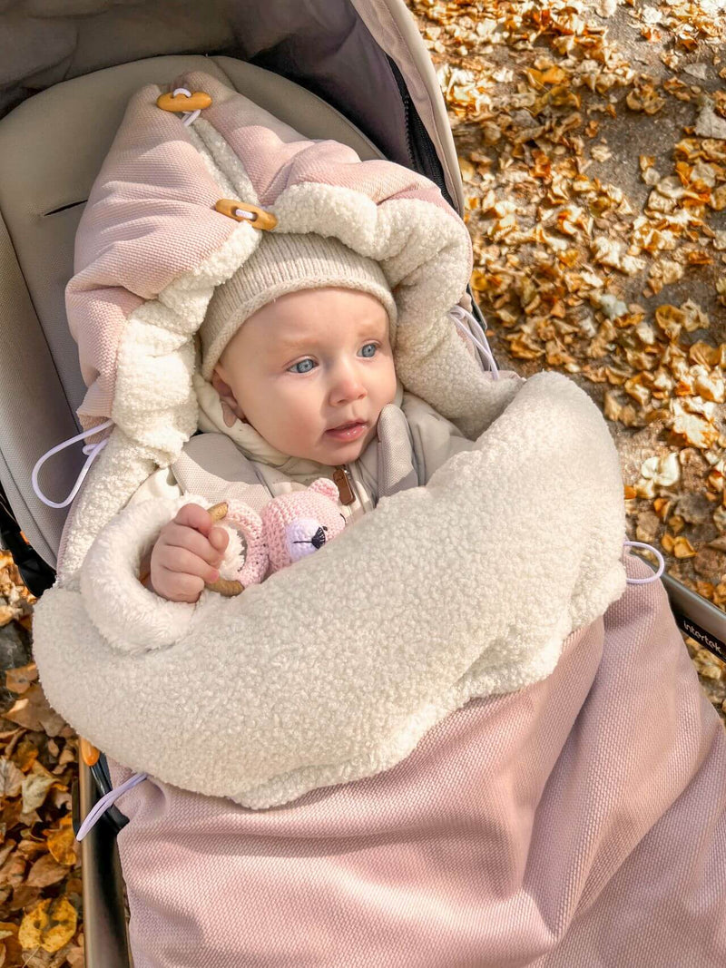 Baby girl in a pink footmuff from The Baby Den UK